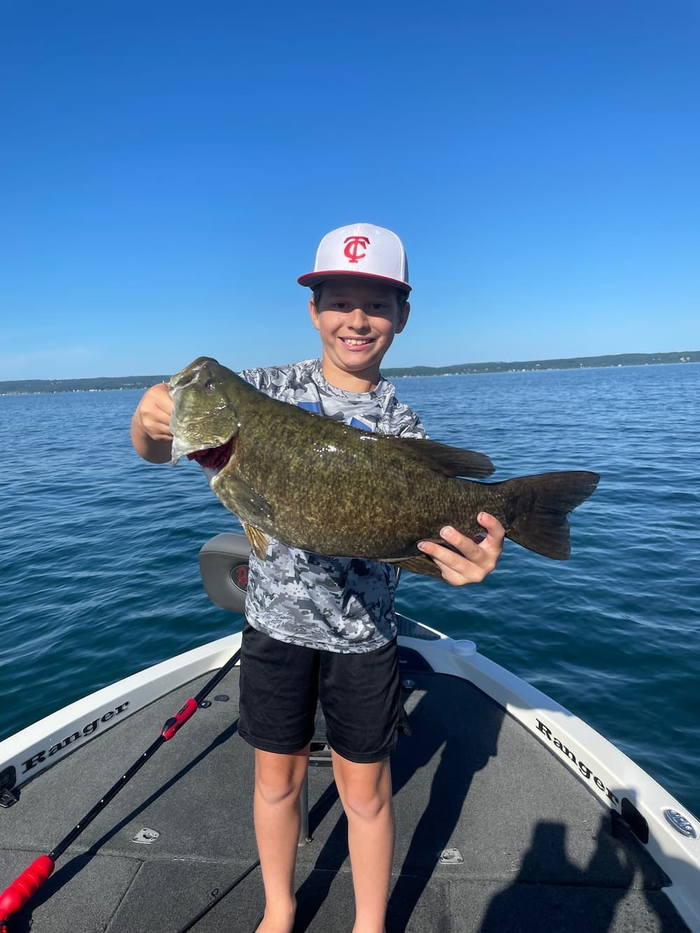 Young angler holding a trophy smallmouth bass caught on a 4-hour fishing charter